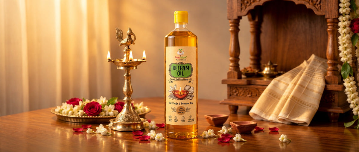 Pancha Deepam oil bottle with a lit brass kuthuvilakku, jasmine and rose petals before a wooden pooja shrine