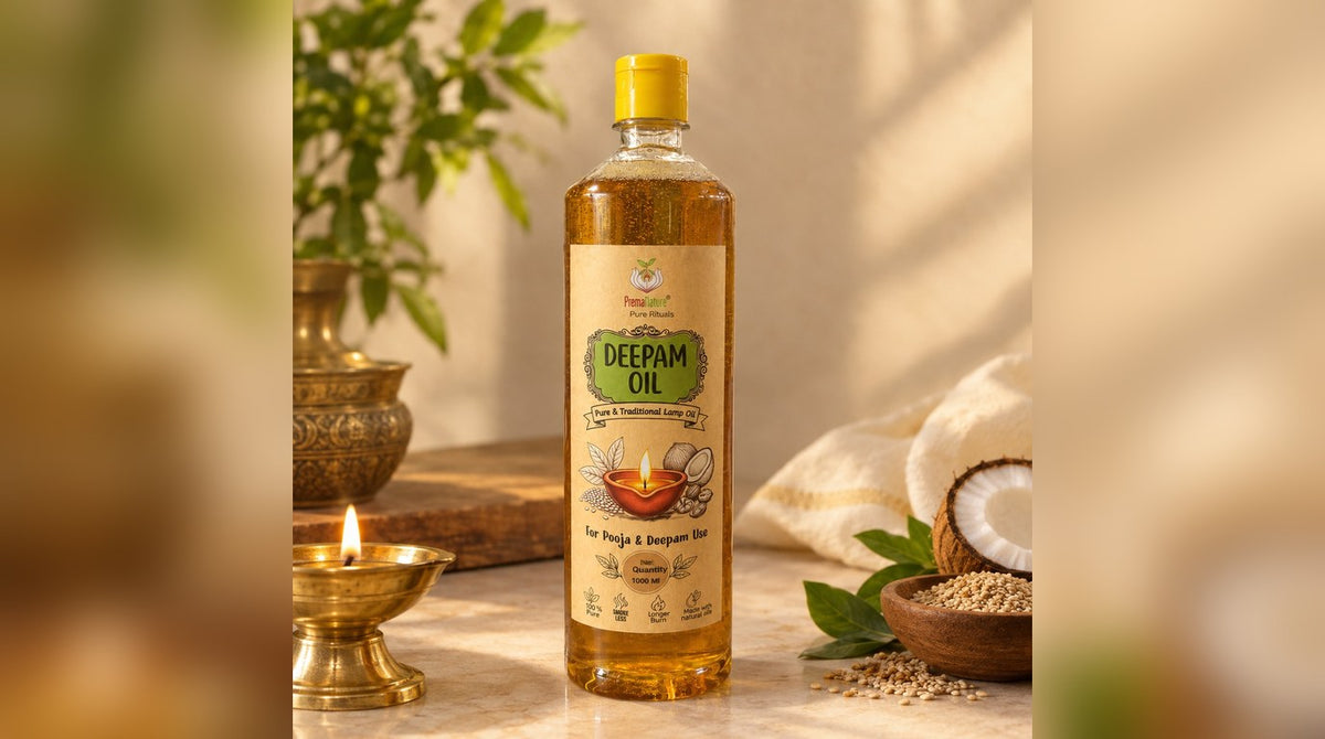 Pancha Deepam oil bottle beside a lit brass diya, coconut and sesame seeds