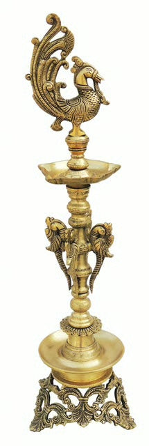 Tall tiered brass oil lamp with peacock finial, elephant-head brackets and pierced base
