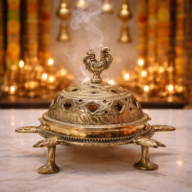 Brass loban dan with a pierced dome lid and peacock finial, standing on four cast feet