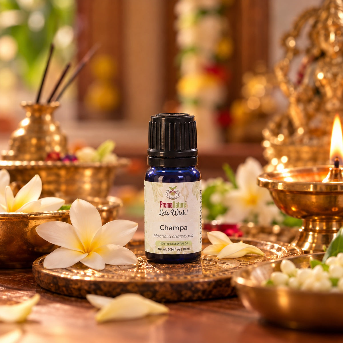 PremaNature Champa essential oil 10 ml (Magnolia champaca) on a brass pooja plate with a diya